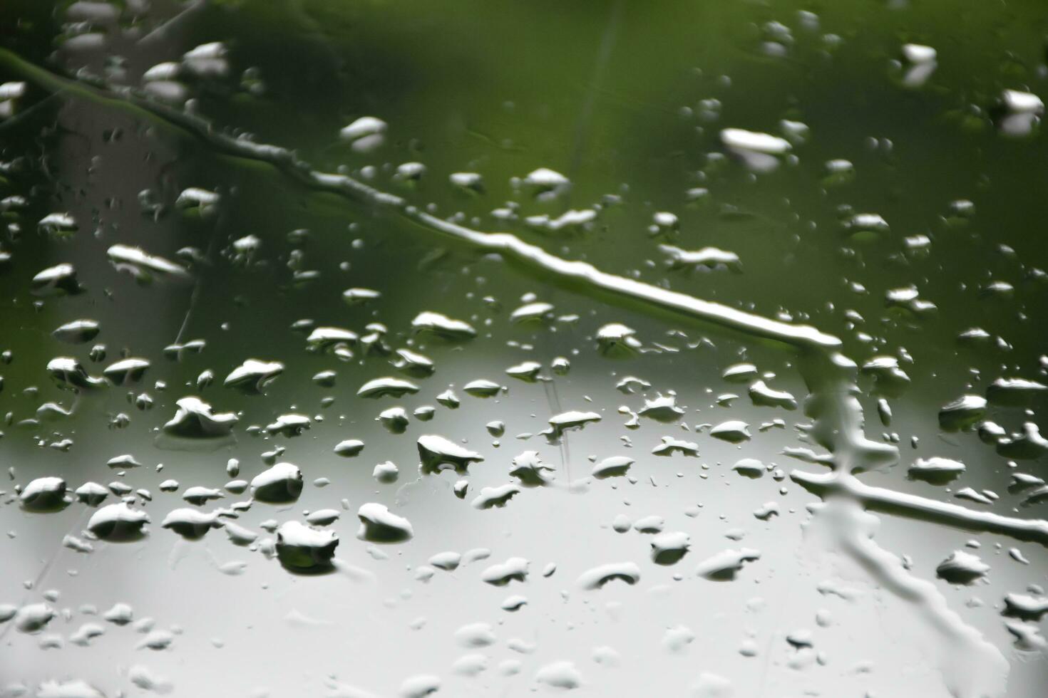 Blurred image of raindrops on the rear view mirror of car, soft focus photo
