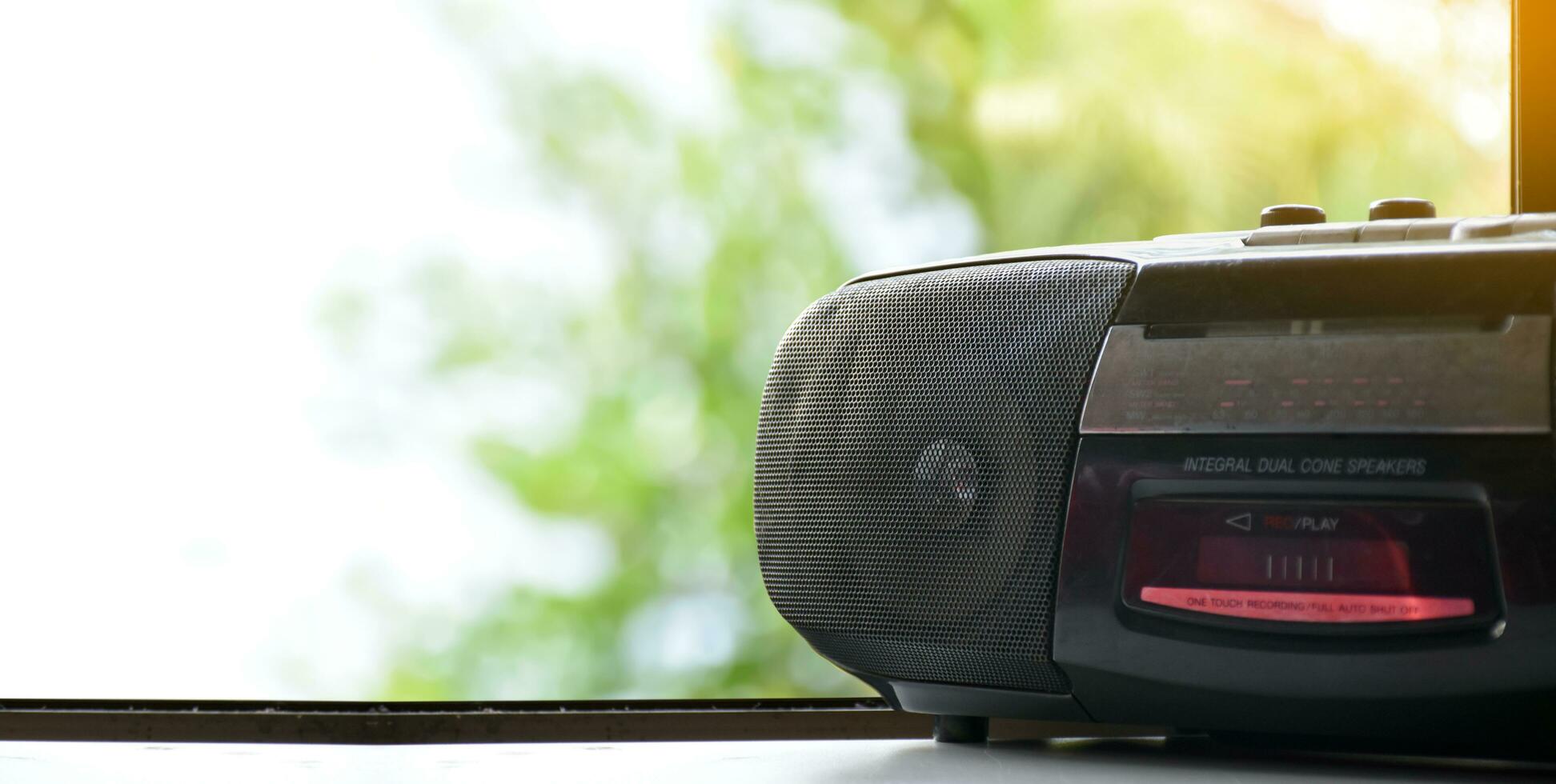 Cassette tape and FM, Am, SW radio player on white table near windows, soft and selective focus. photo