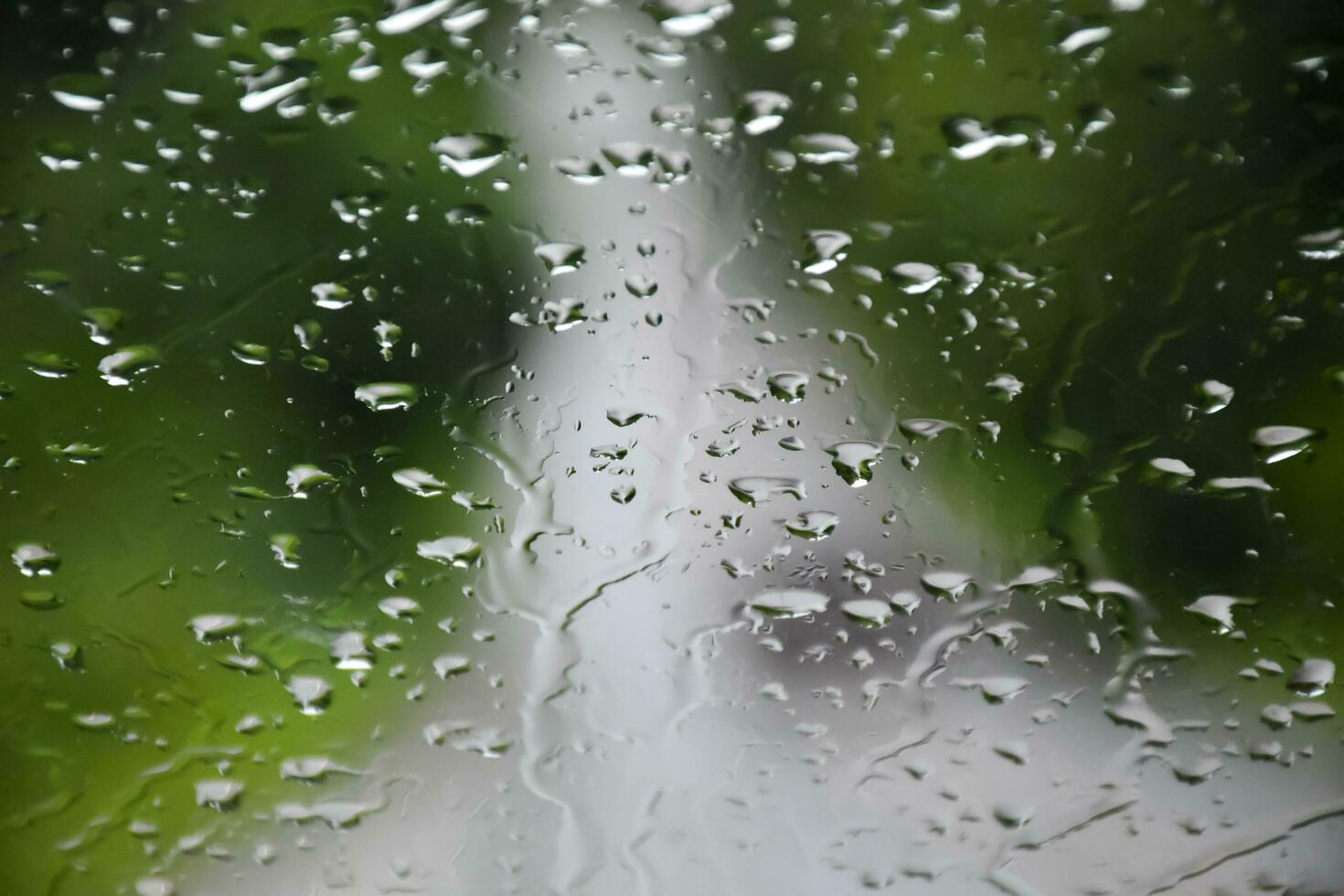 Blurred image of raindrops on the rear view mirror of car, soft focus photo