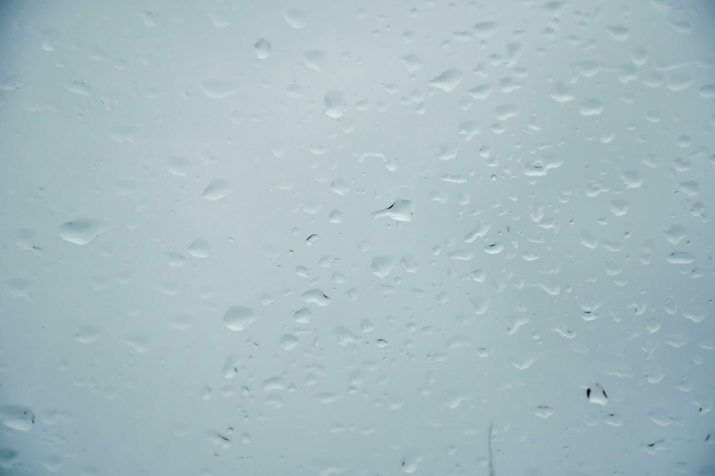Blurred image of raindrops on the rear view mirror of car, soft focus photo