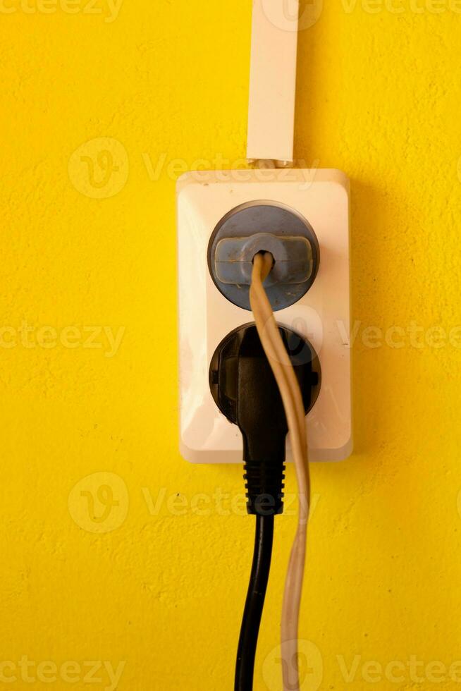 Double white socket yellow wall. Electric wires. photo