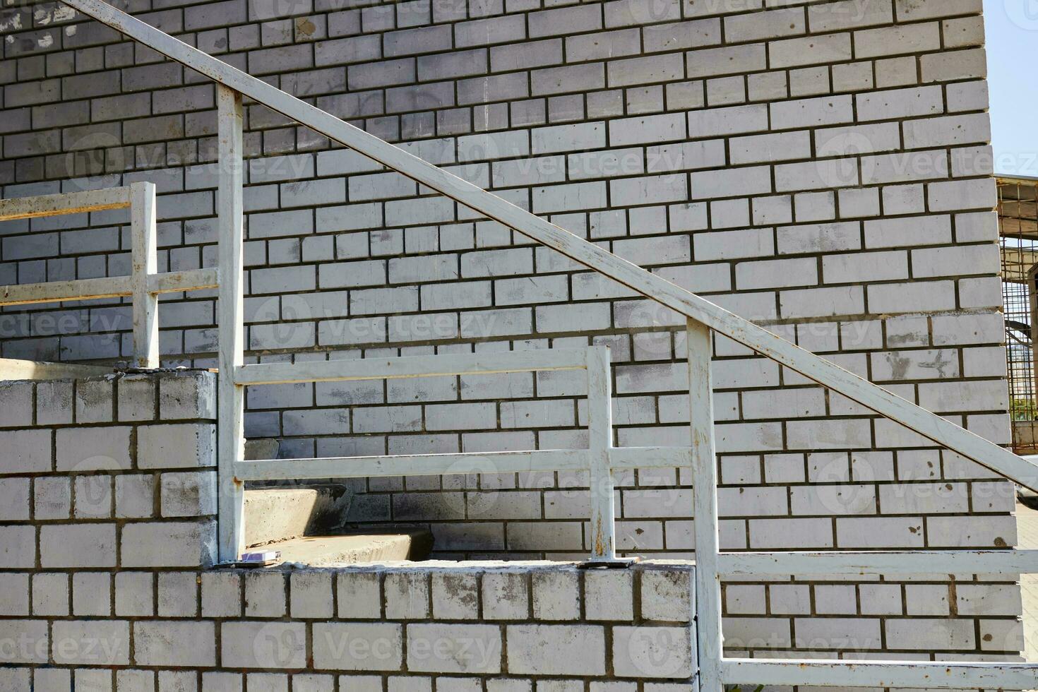 blanco ladrillo pared y escalera alpinismo escaleras. casa foto