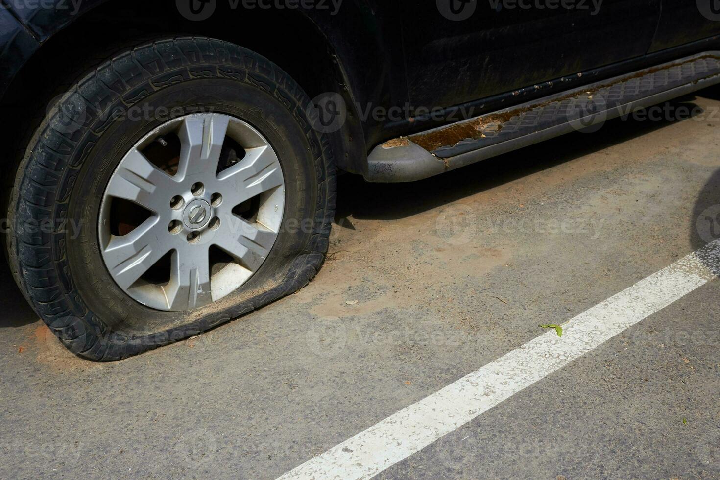 Photo of flat tire of car, torn tire.