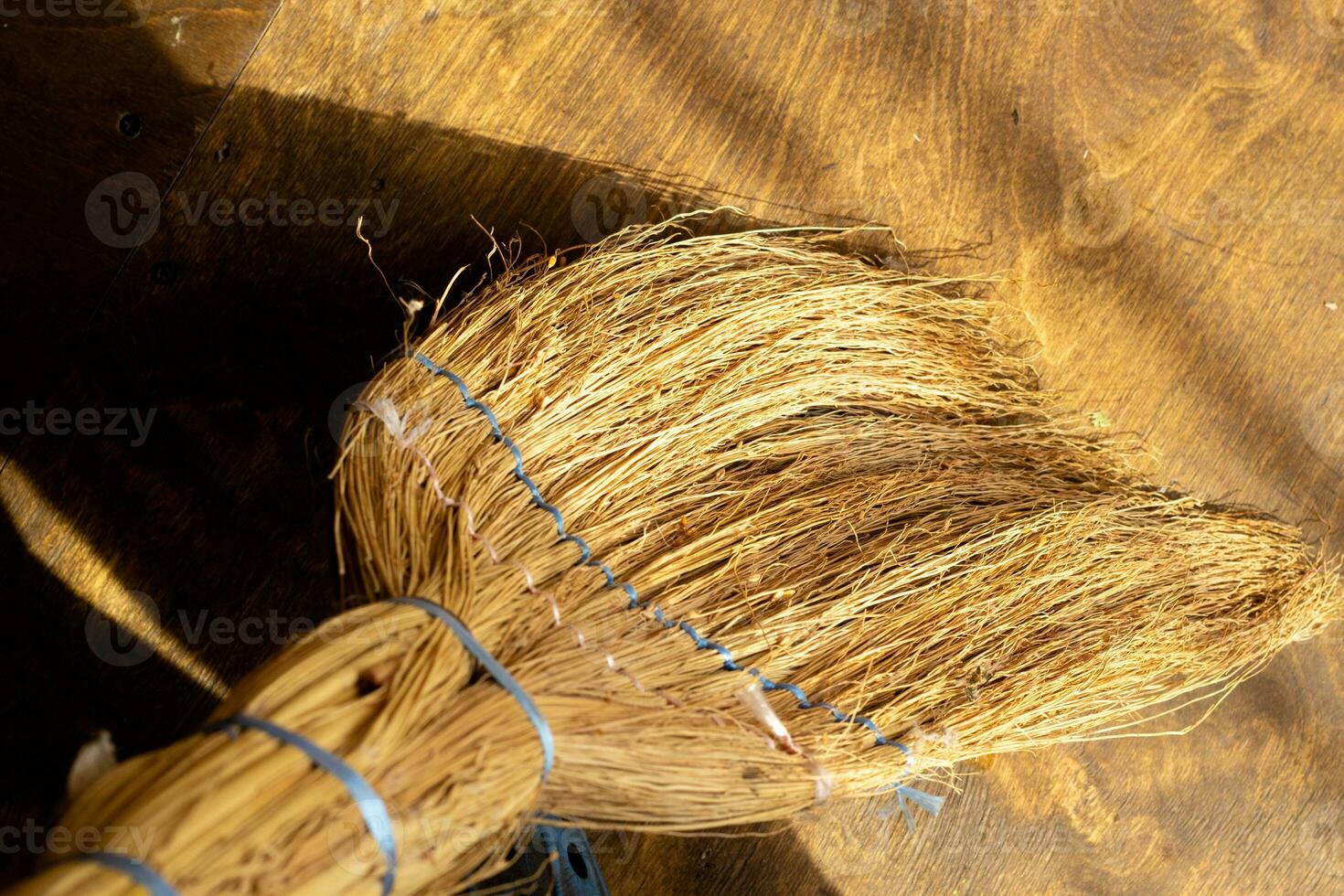 Escoba en el antecedentes de el madera contrachapada piso. foto