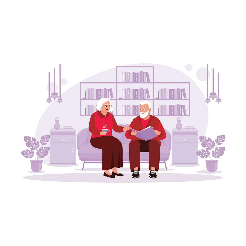 An elderly couple is sitting in the living room enjoying a hot cup of tea and looking at a memory album. Trend Modern vector flat illustration.