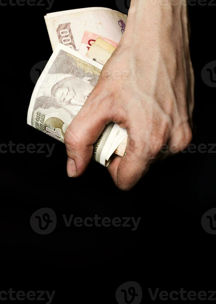 Palm of a peasant woman with old banknotes on a black fabric. Closeup photo