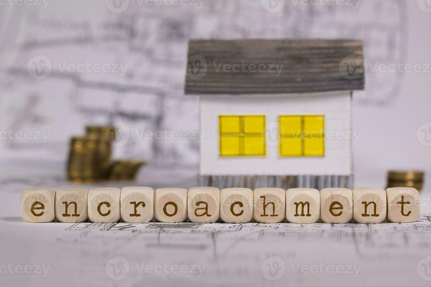 Word  ENCROACHMENT composed of wooden letters. Small paper house in the background. photo