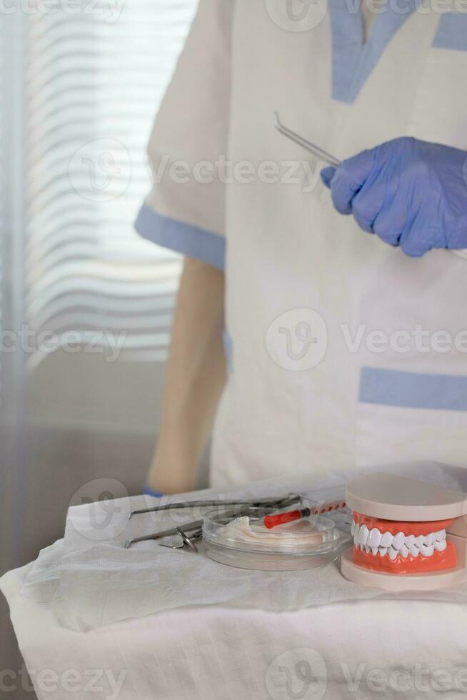 estéril algodón servilletas, mandíbula modelo y estomatológico herramientas en un mesa. foto