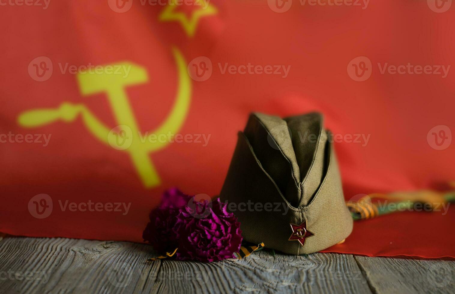 militar gorra, claveles, Santo Jorge cinta en un de madera superficie. foto