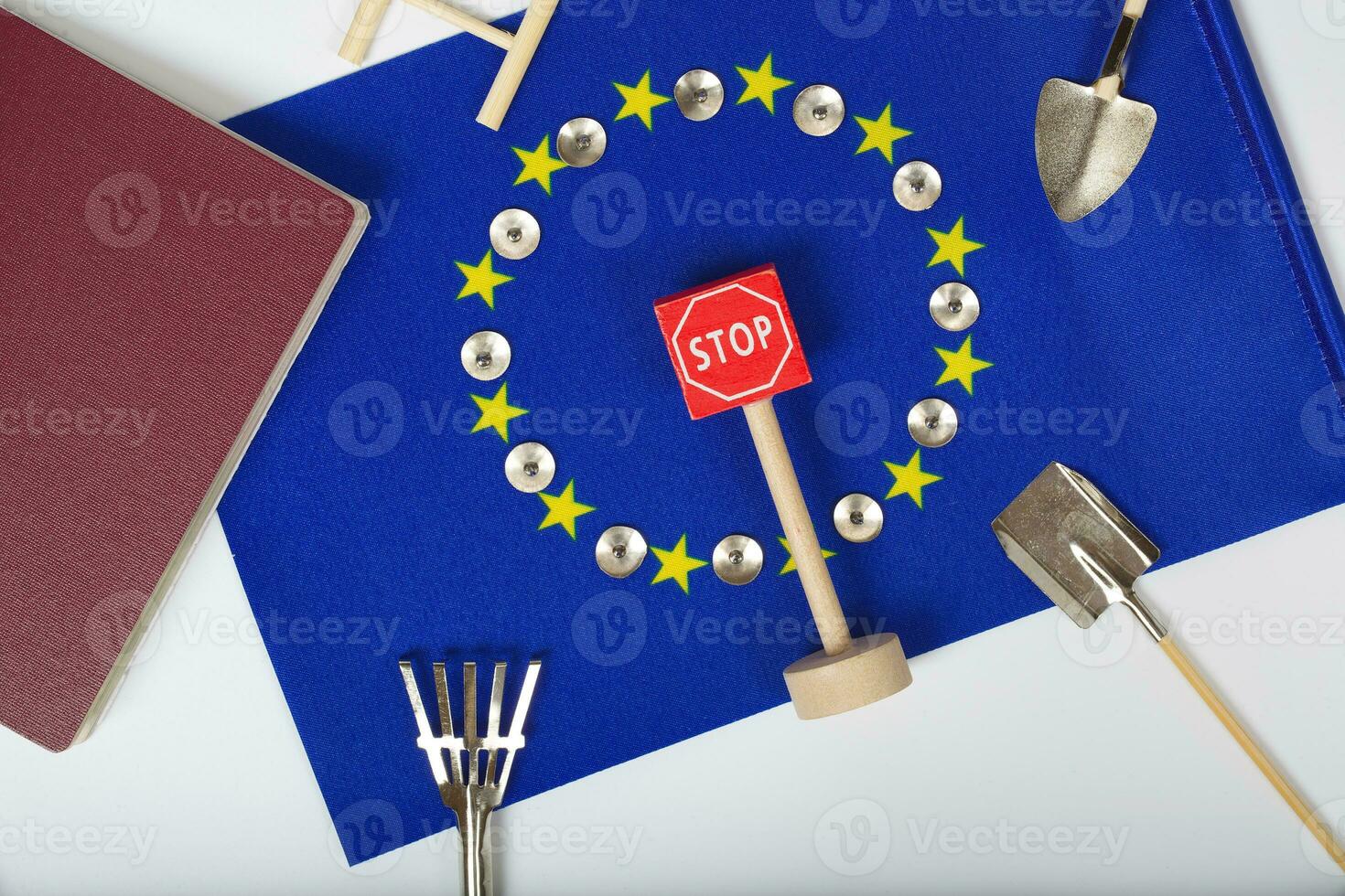 Agricultural tools,a card with access forbidden,pins,and a passport on an European flag.Closeup photo