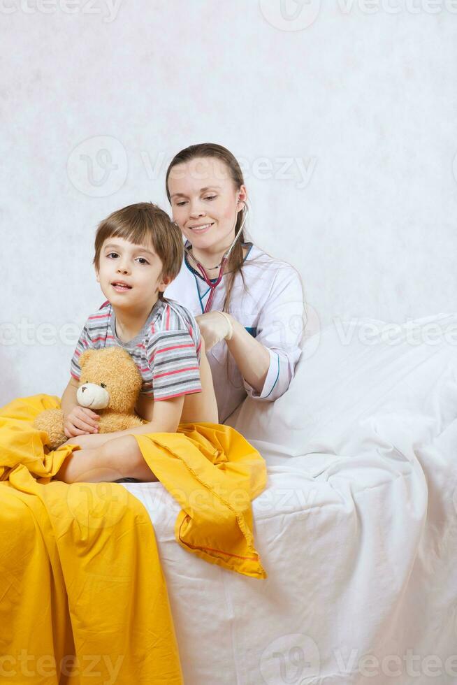 un niño y un pediatra en su gabinete foto