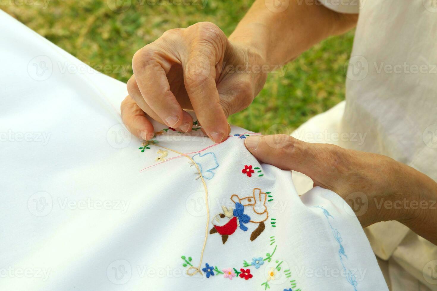 un antiguo mujer es bordar en el blanco cobija foto