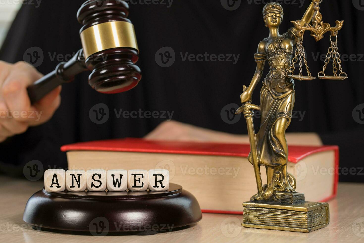 Word ANSWER composed of wooden dices. Wooden gavel and statue of Themis in the background. photo