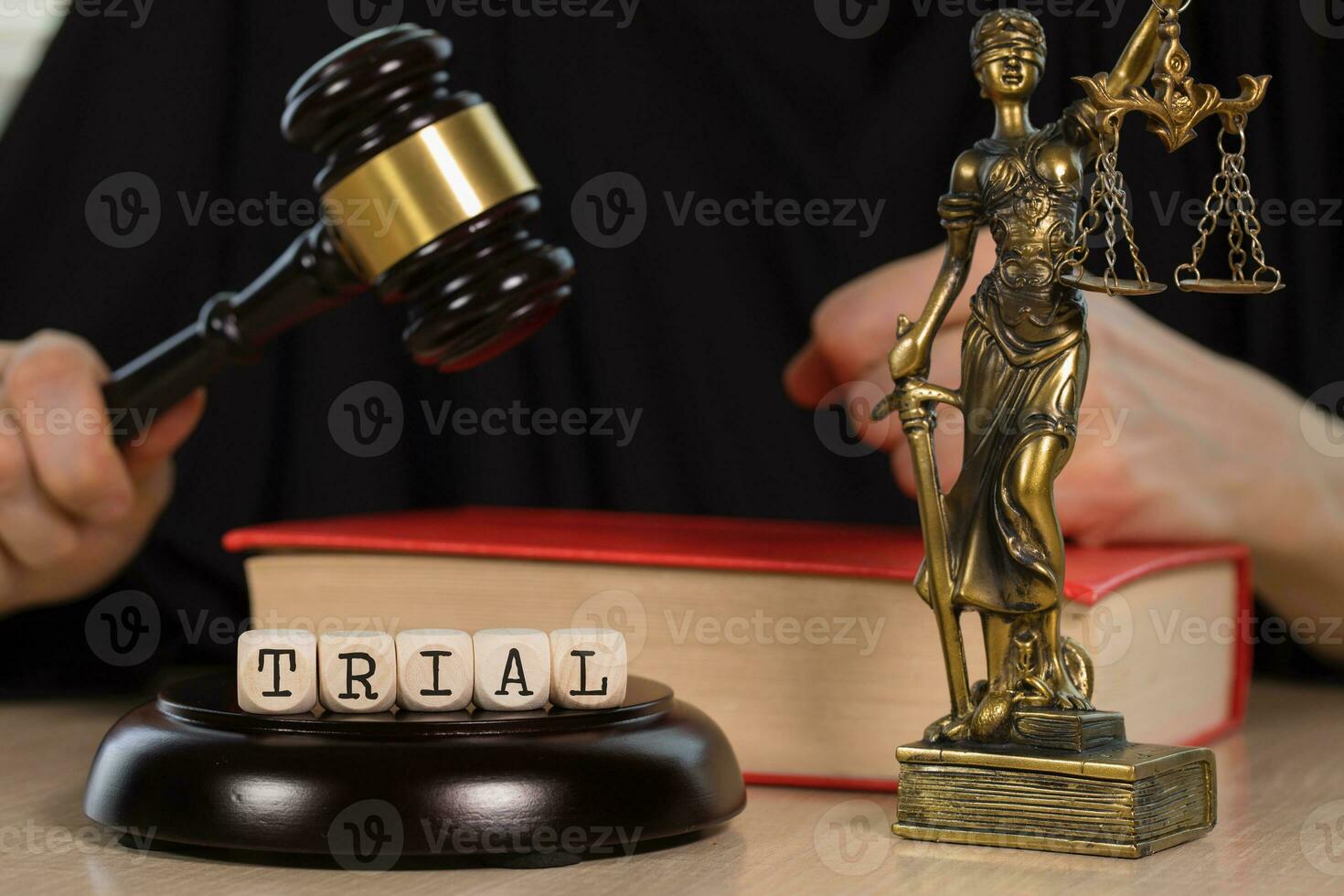 Word TRIAL composed of wooden dices. Wooden gavel and statue of Themis in the background. photo
