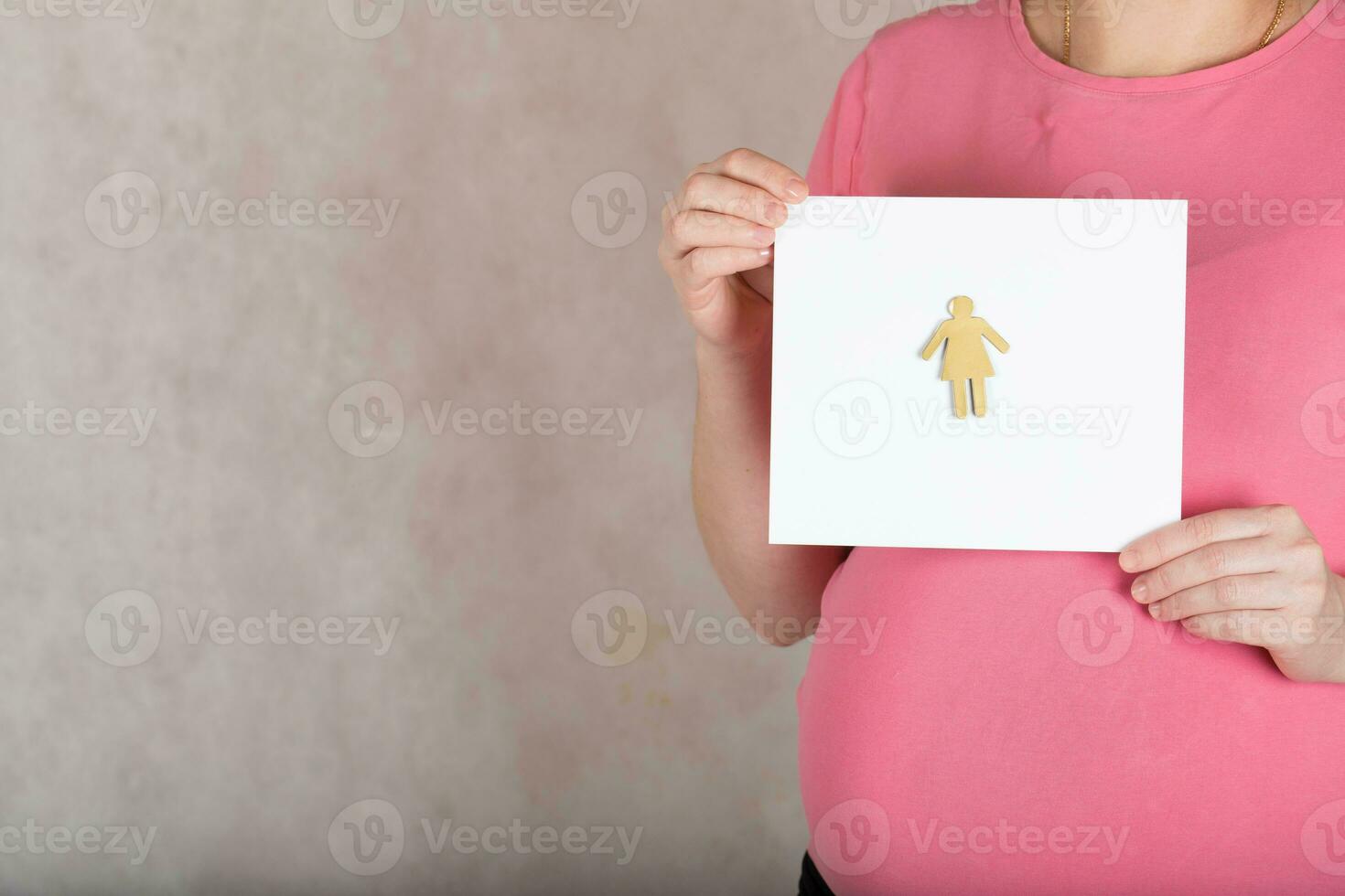 Young pregnant between 30 and 35 years old woman keeps a  blank white sheet of paper. photo