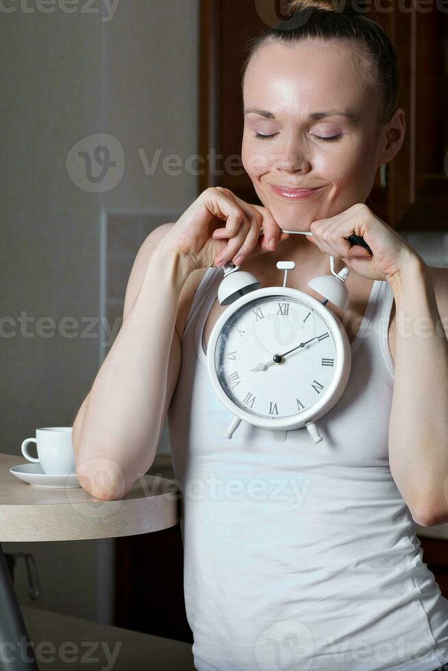 Young caucasian lady is drinking espresso at bar table in the kitchen photo