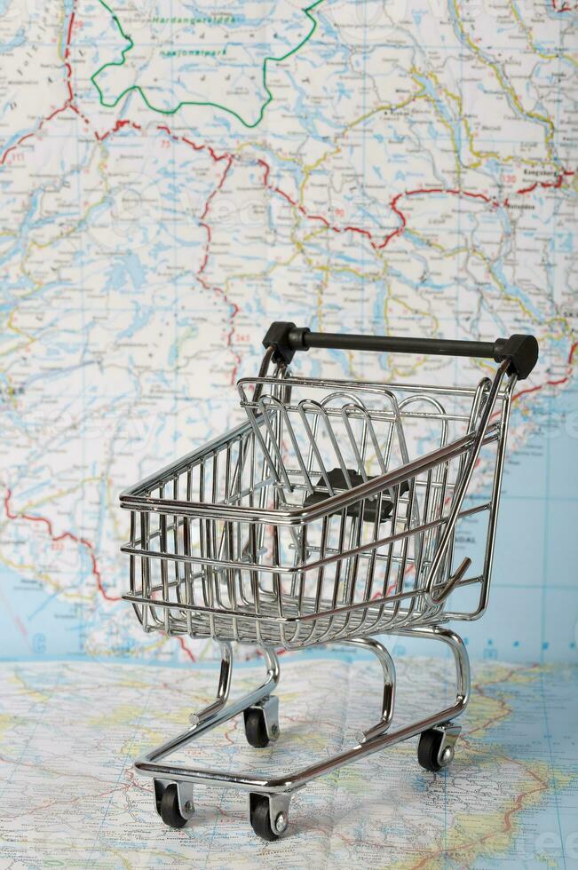 Mini shopping cart on a map. photo