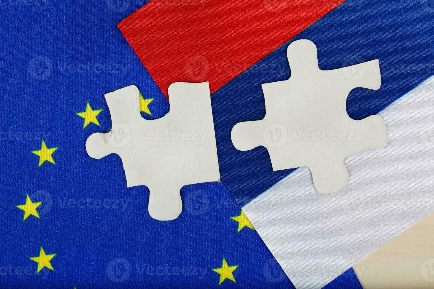 Two pieces of puzzle on European and Russian flag. Background photo