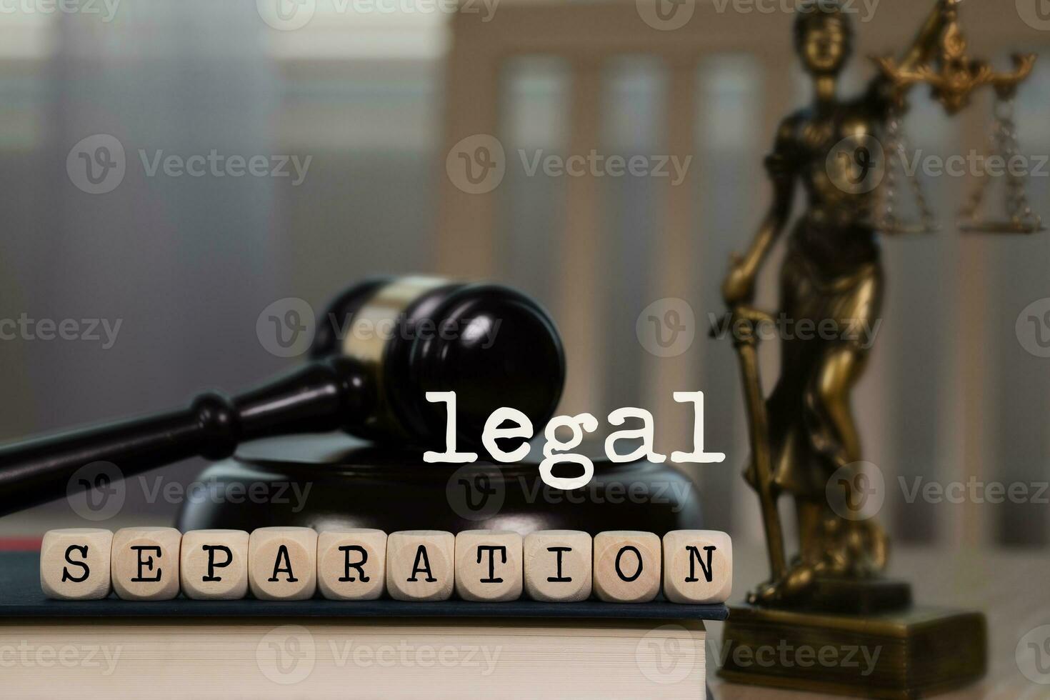 Words LEGAL SEPARATION composed of wooden dices. Wooden gavel and statue of Themis in the background. photo