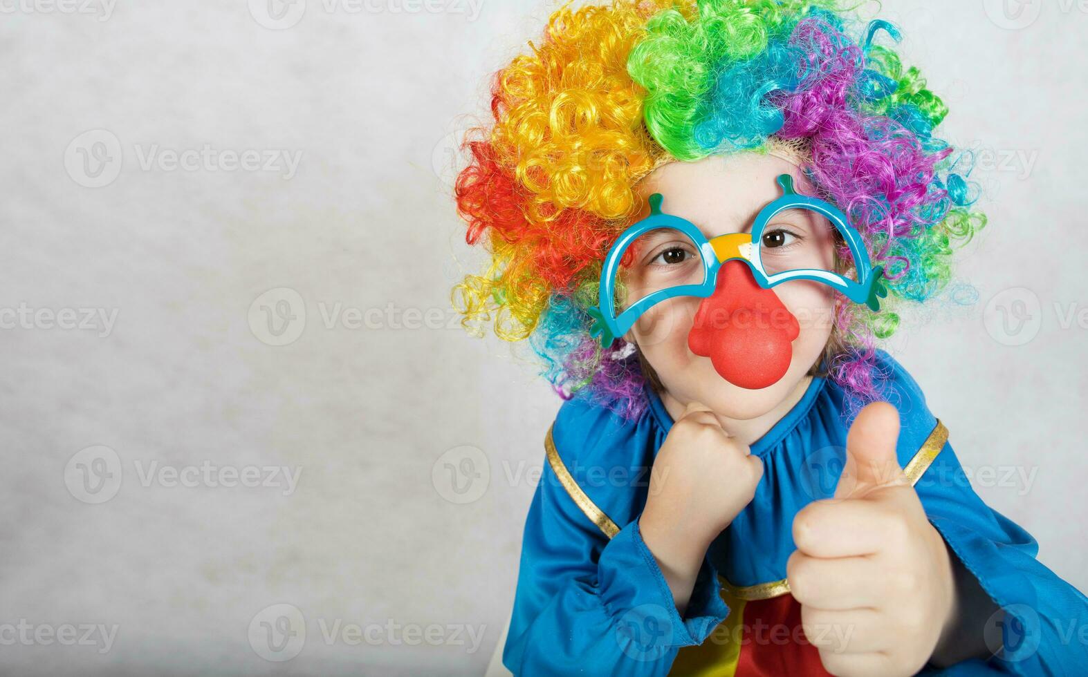 Boy of five years dressed in the costume of a clown and funny eyeglasses with red nose. photo