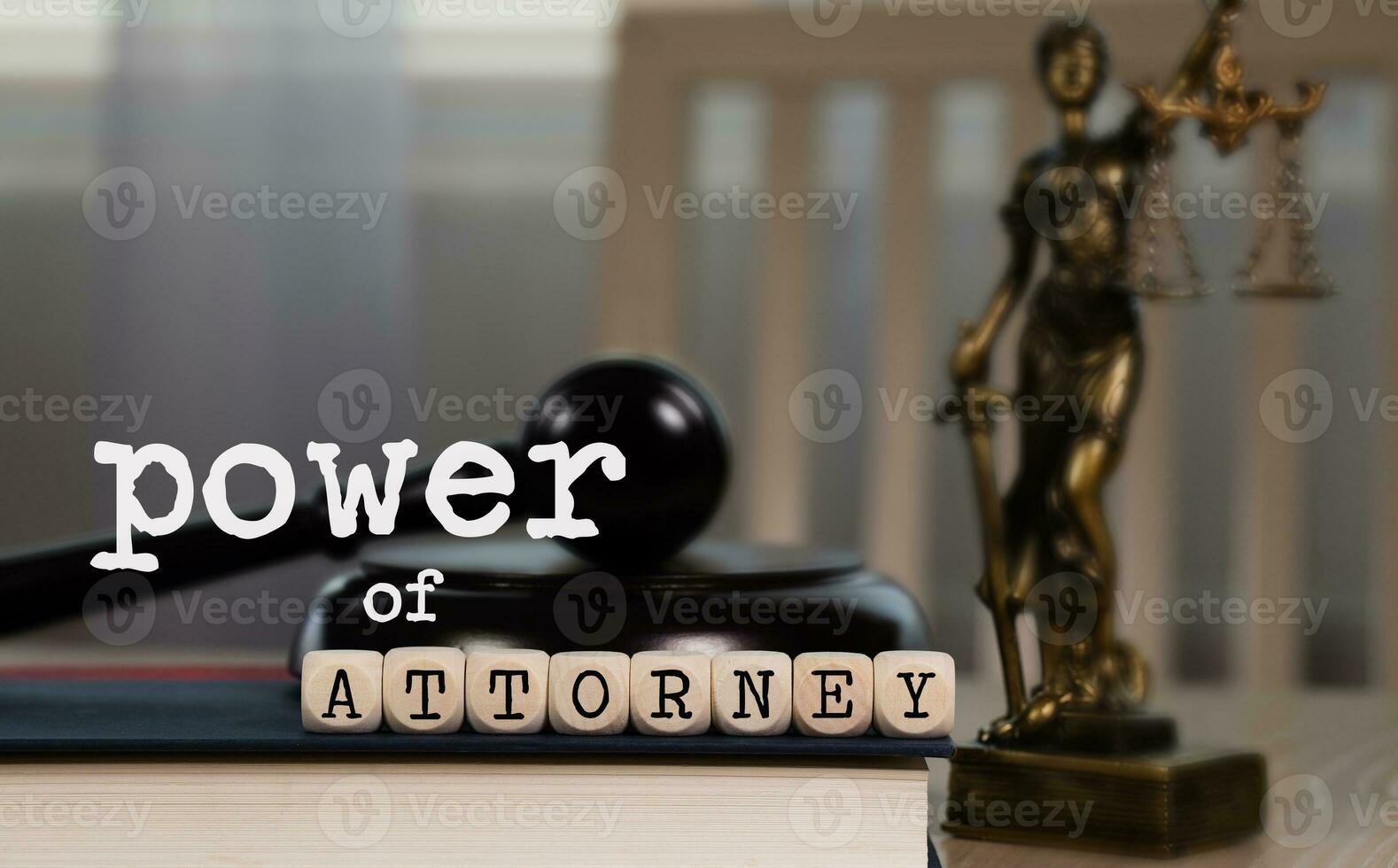 Words POWER OF ATTORNEY  composed of wooden dices. Wooden gavel and statue of Themis in the background. photo