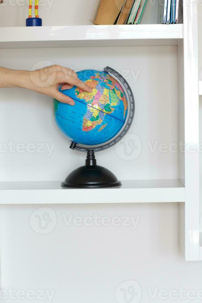 Colorful paper globe on a book shelf. photo