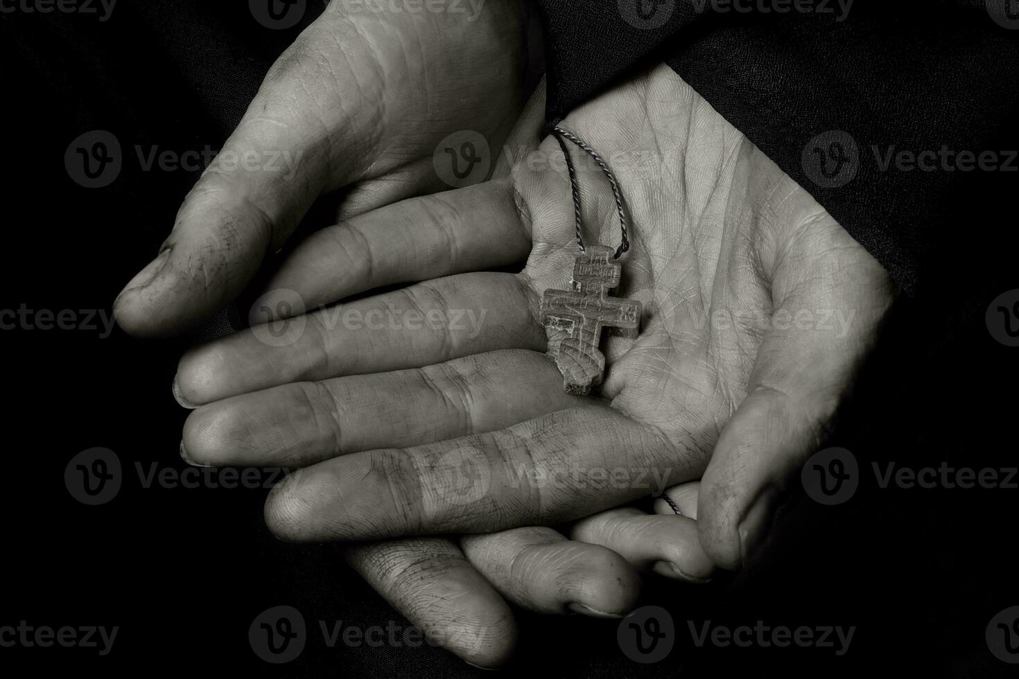 Wooden handmade cross in the palm of a peasant woman. photo