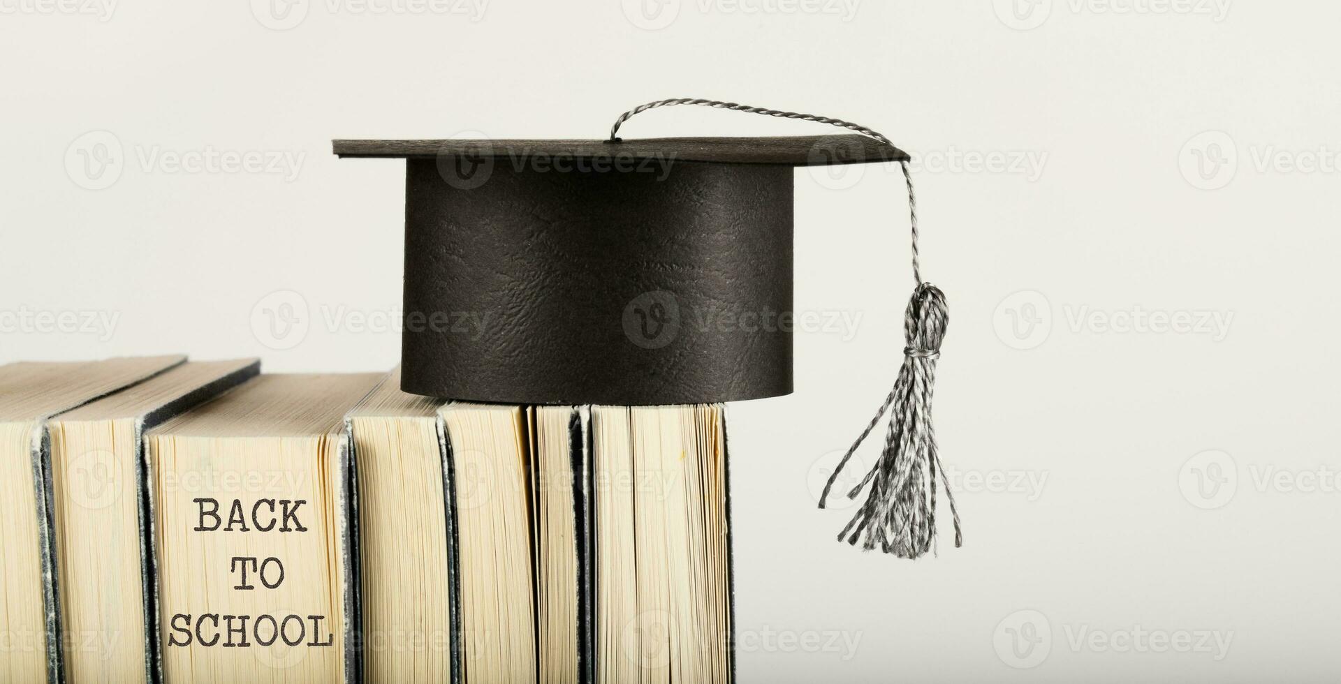 Academic hat on books. Free space for a text. photo