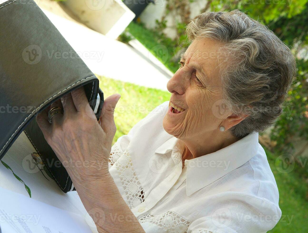 un antiguo mujer es acecho un tableta foto