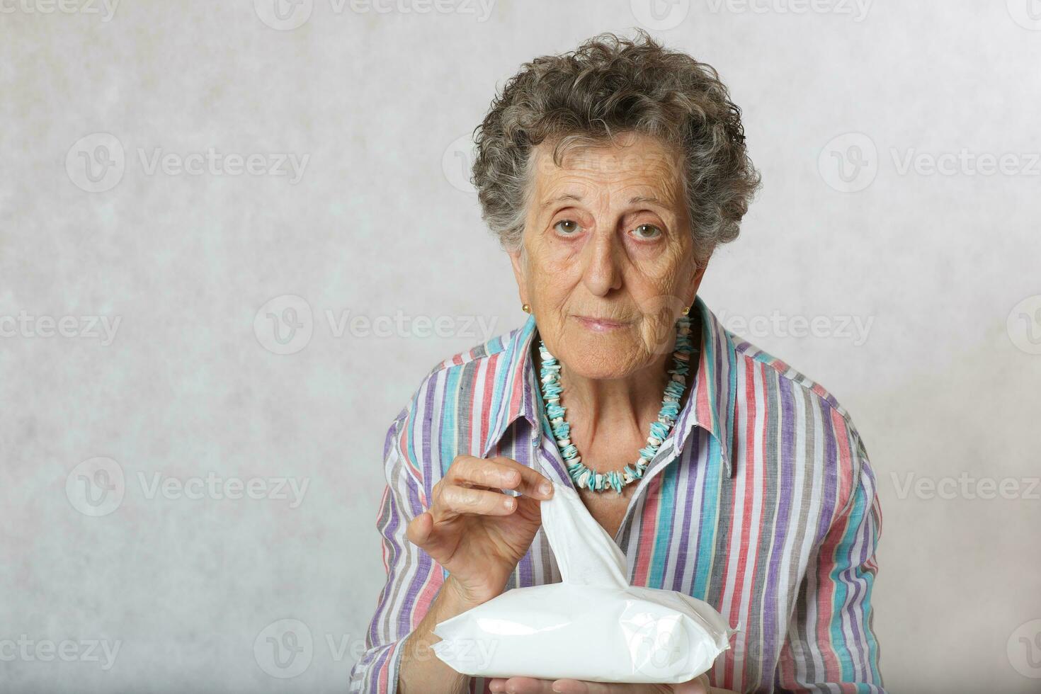 Senior woman wants to clean her hands with wet wipes photo