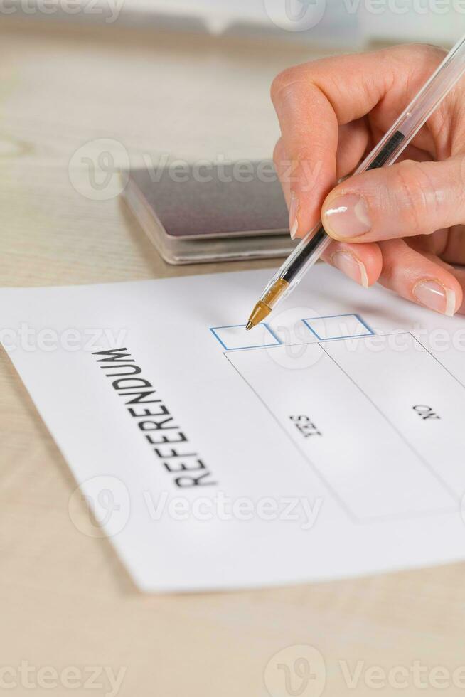 Referendum ballot paper, black pen, and passport on the table. photo