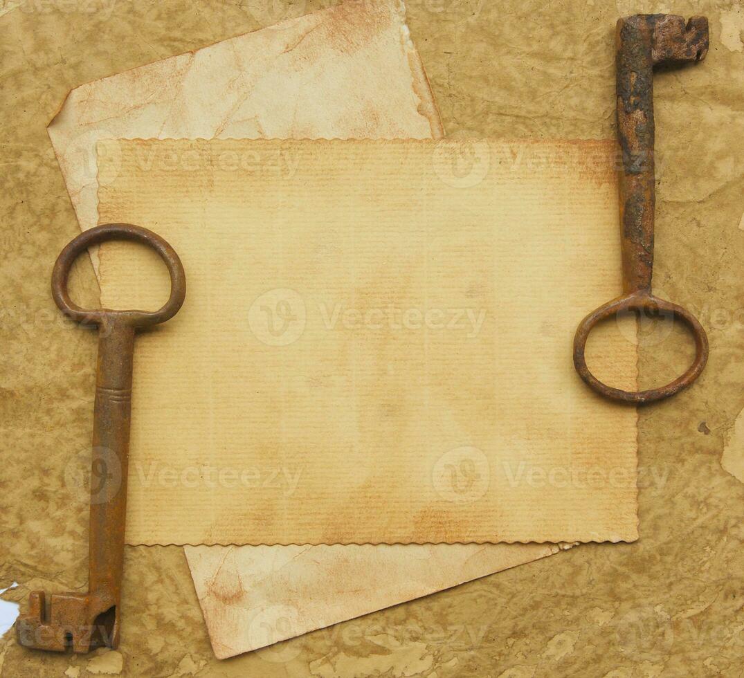 Two old rusted keys on an old surface. photo