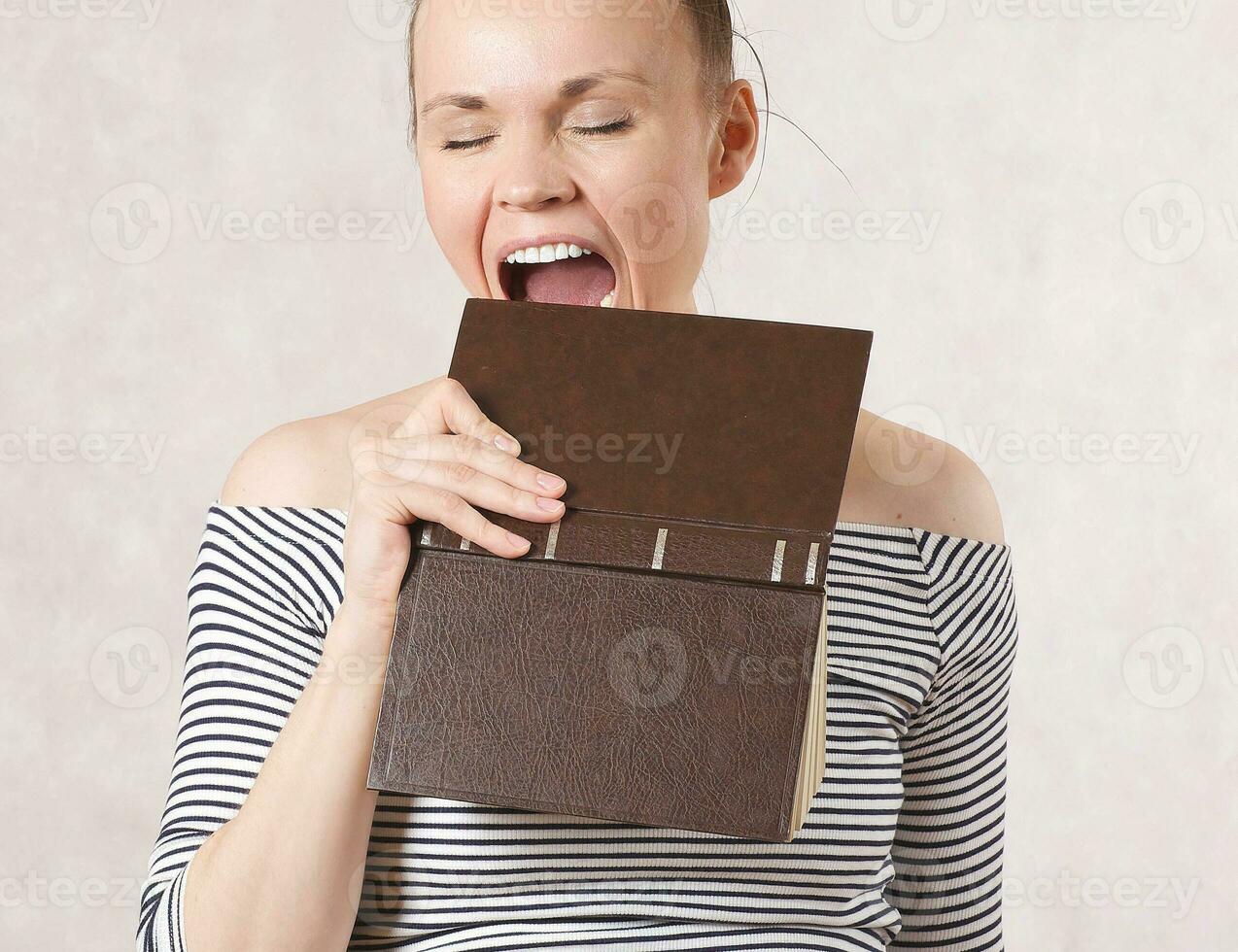 A young woman and a hardback book. Free space for a text photo