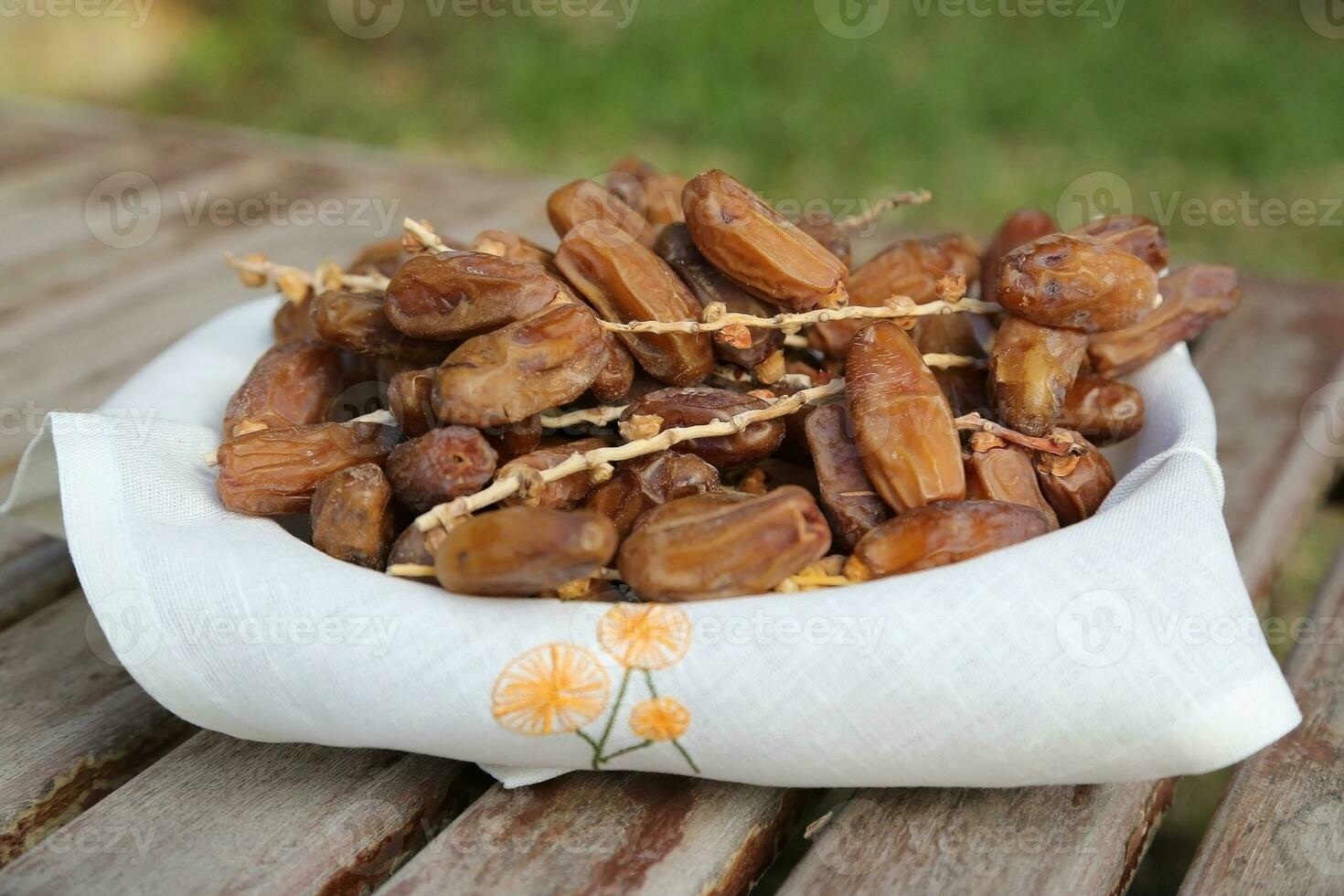 Tunisian dates on a twig in the woven plate photo