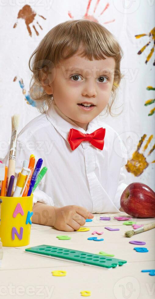 Boy of four years in white shirt with red bow photo