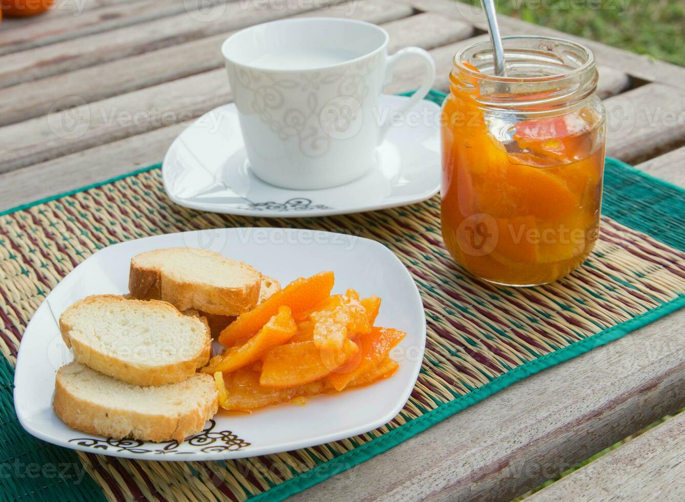 Homemade tangerine marmalade on the small square dessert plate photo
