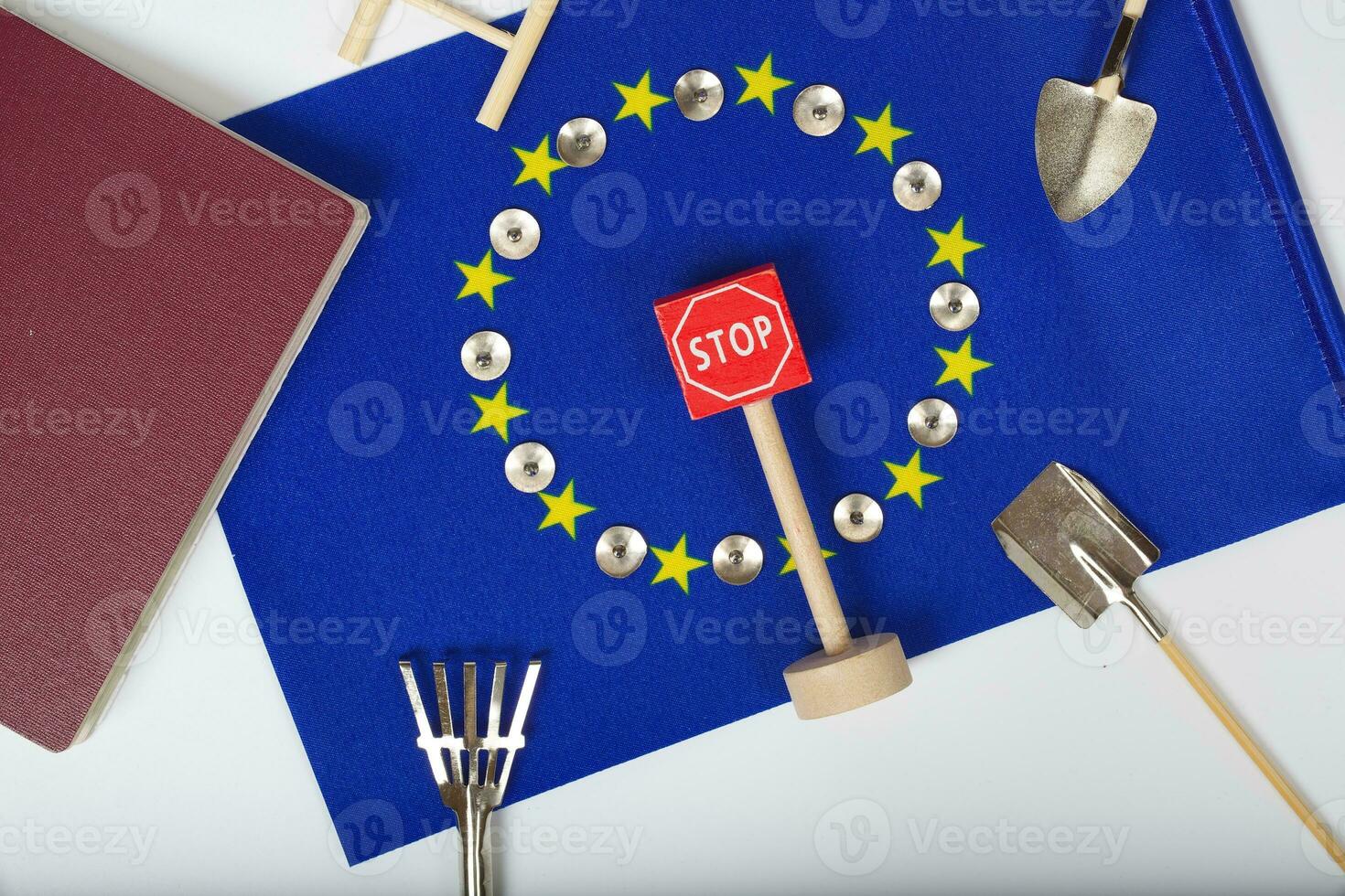 Agricultural tools,a card with access forbidden,pins,and a passport on an European flag.Closeup photo