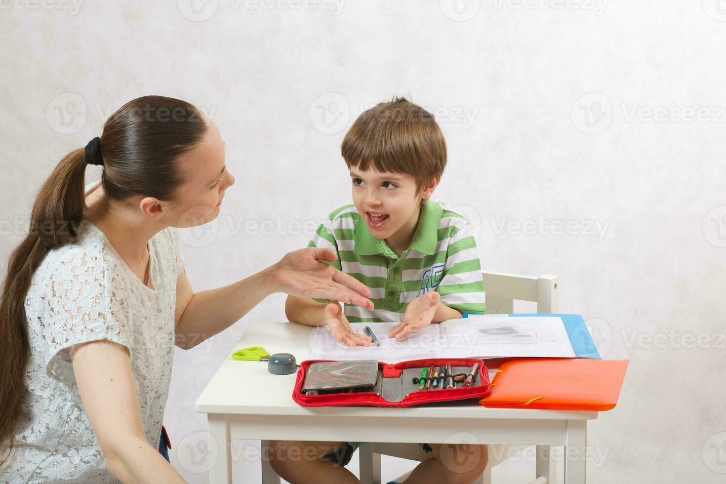 The mother checks the homework of her son photo