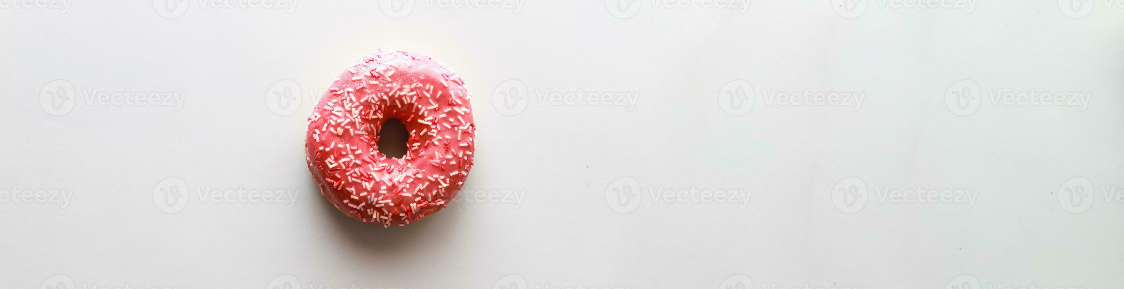 Banner Flat lay pink donut on color background. Dessert with icing photo