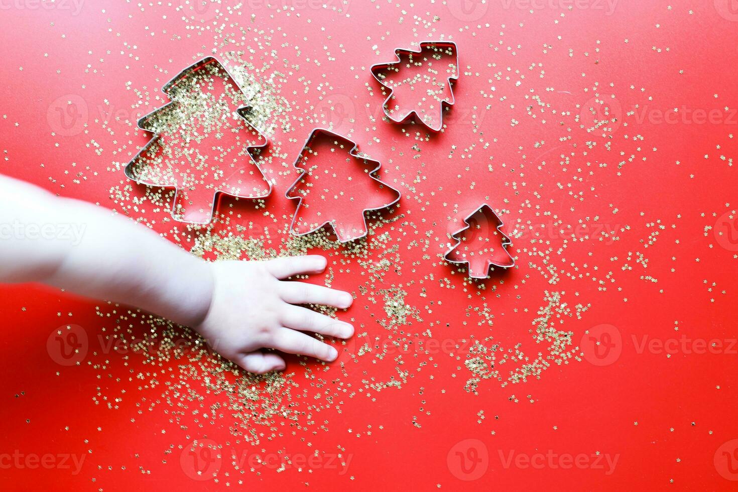The child makes Christmas cookies. Child is hand holding a cookie cutter photo