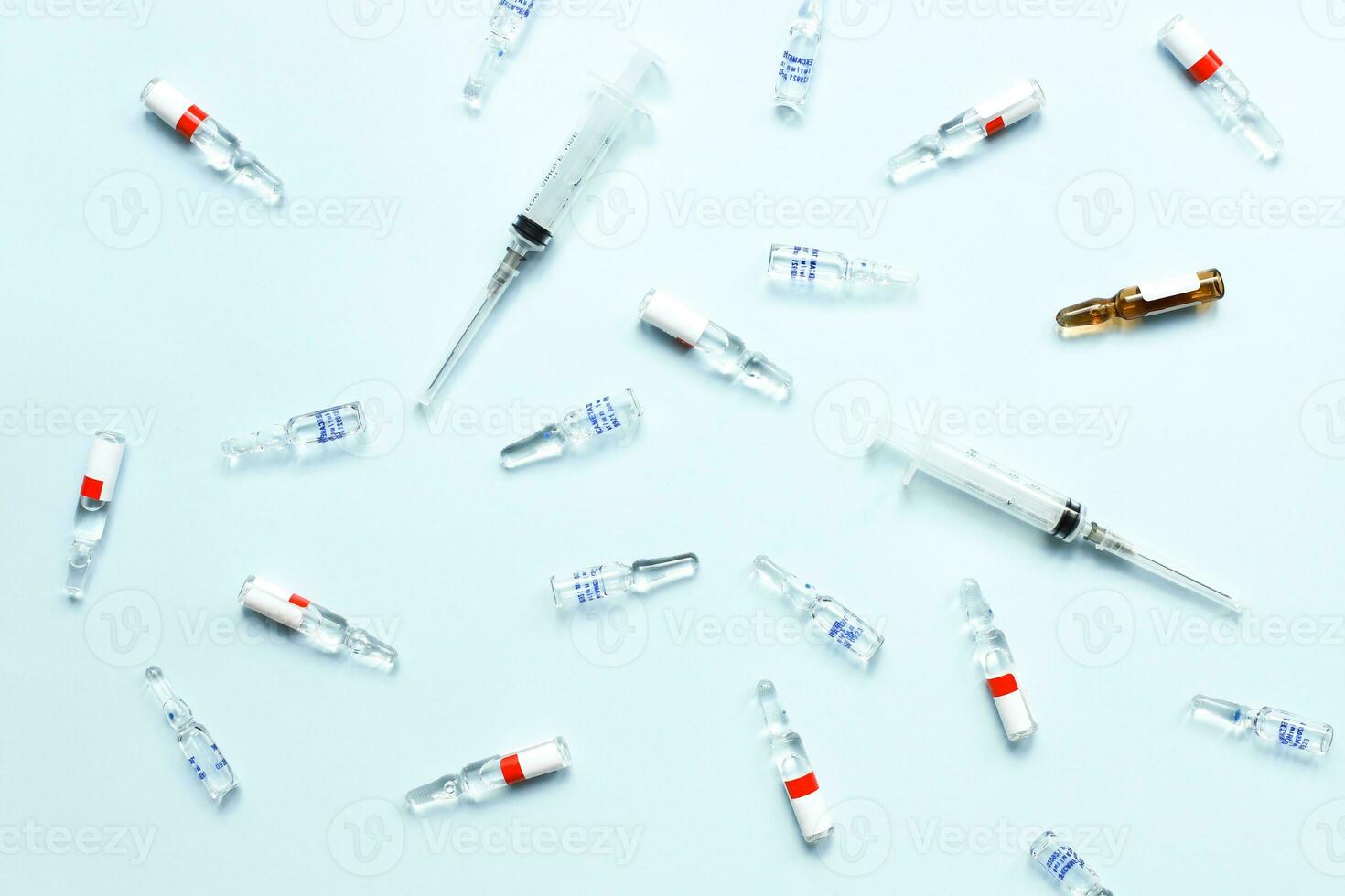 Pattern of ampoules and syringes. Vaccination. Bird flu. Covid 19. Flat lay ampoules and medicines on a blue background photo