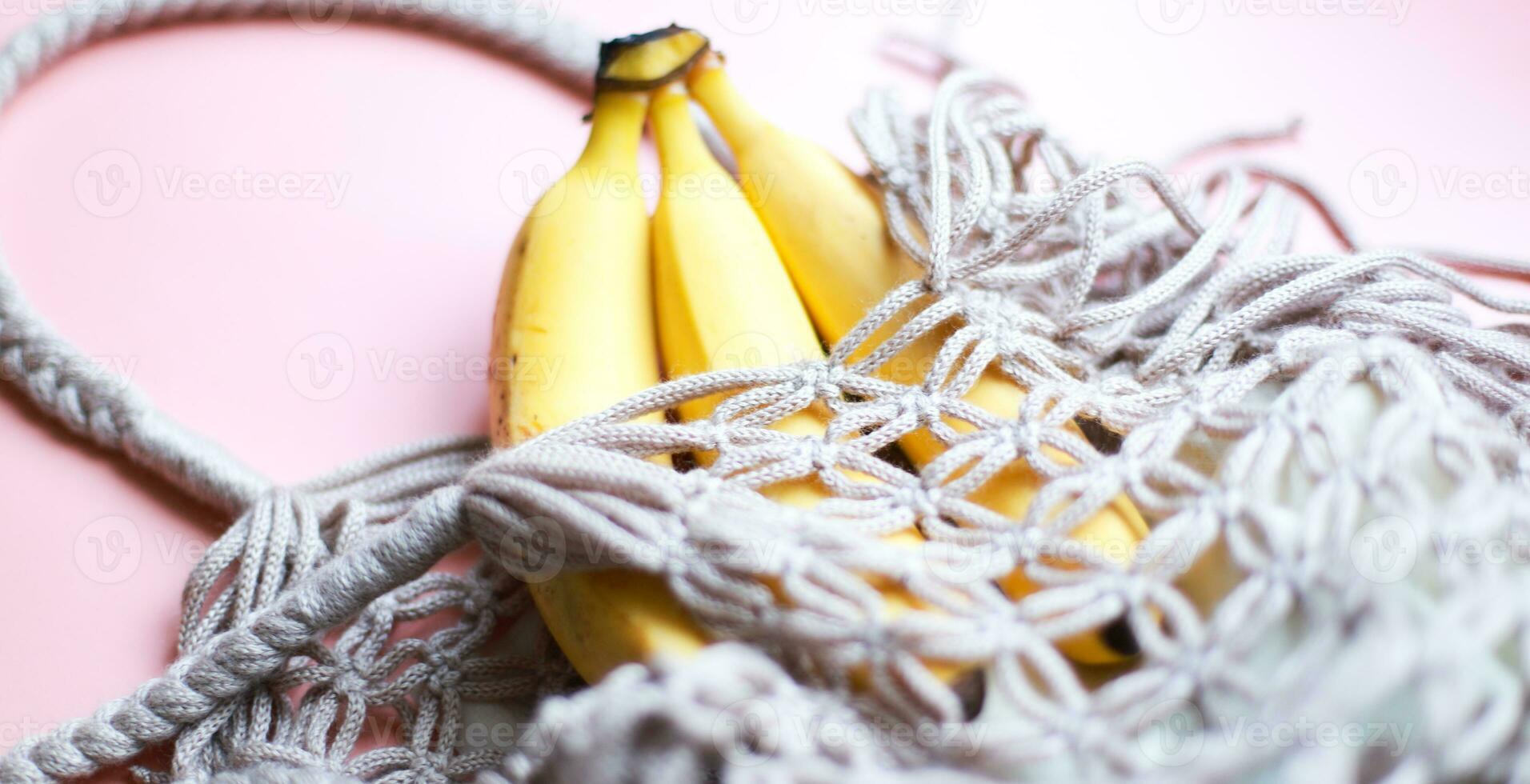 Banner A bunch of bananas in a shopping bag. Mesh bag. zero west. Vegan, fruitarianism photo
