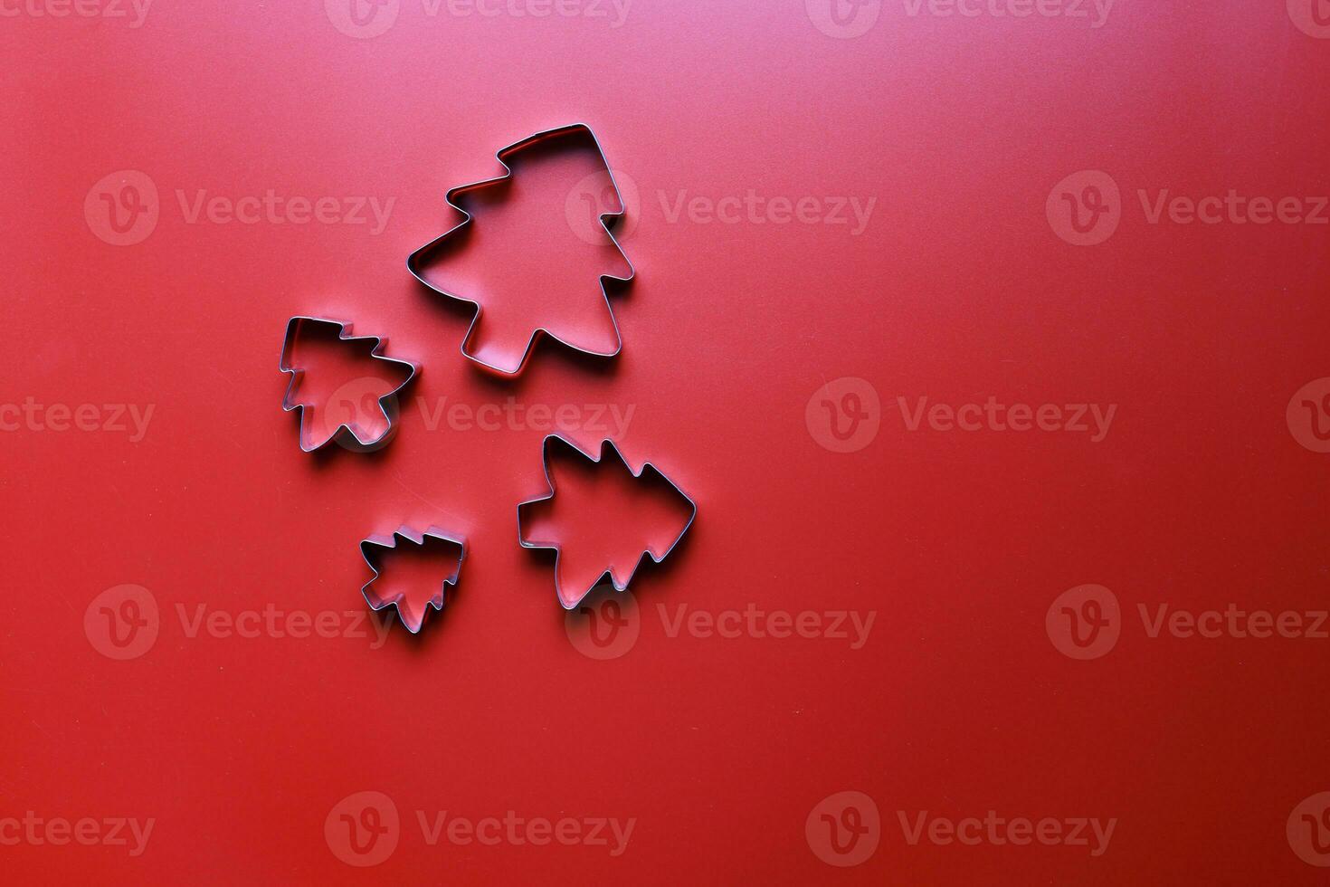 Flay lay molds for cookies in the shape of Christmas trees on a red background photo