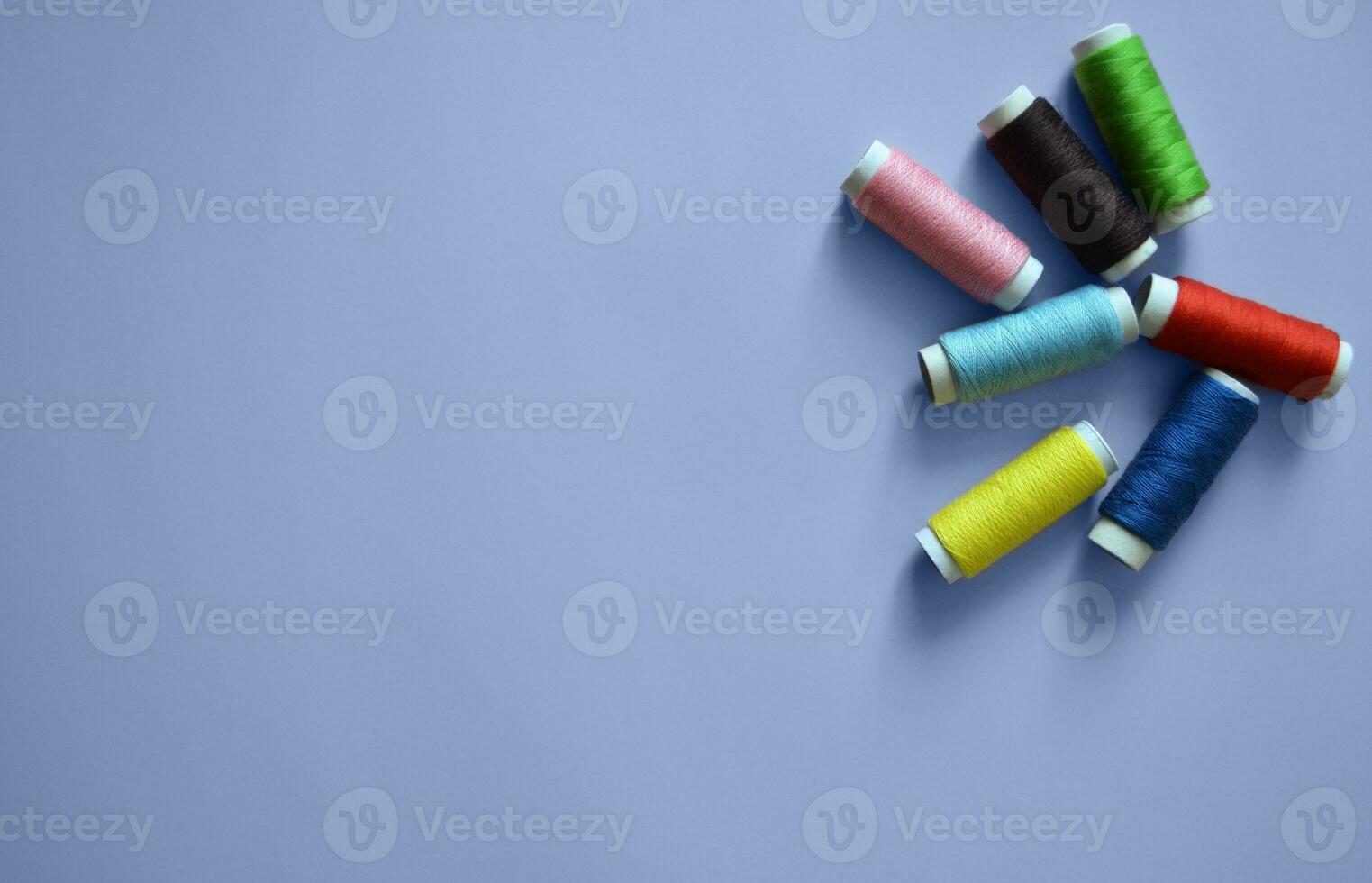 spools of thread on a blue background, a banner for an atelier, tailoring, sewing threads, photos for a textile factory, a place for text