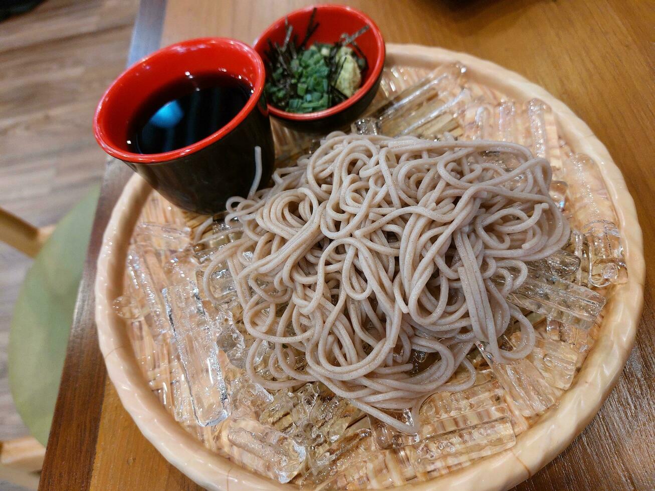 Japanese food called Sarusoba, the noodles are placed on ice on a bamboo tray, served with sauce and side dishes. photo