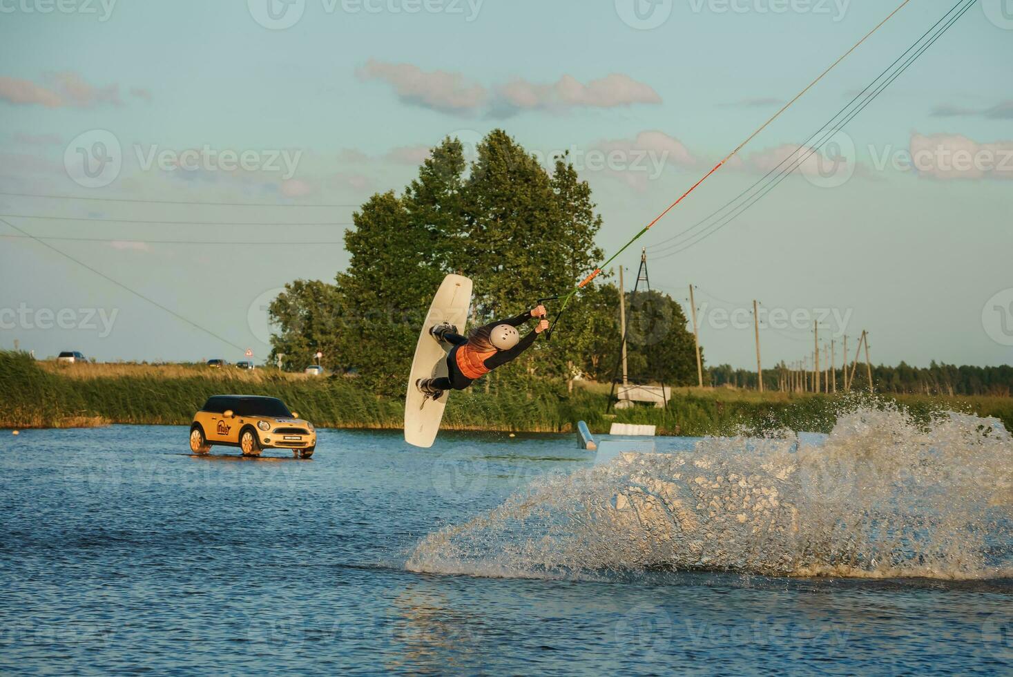 Wake boarding female sportsman girl jumping high wake boarding raley trick with huge water splash in the cable park photo