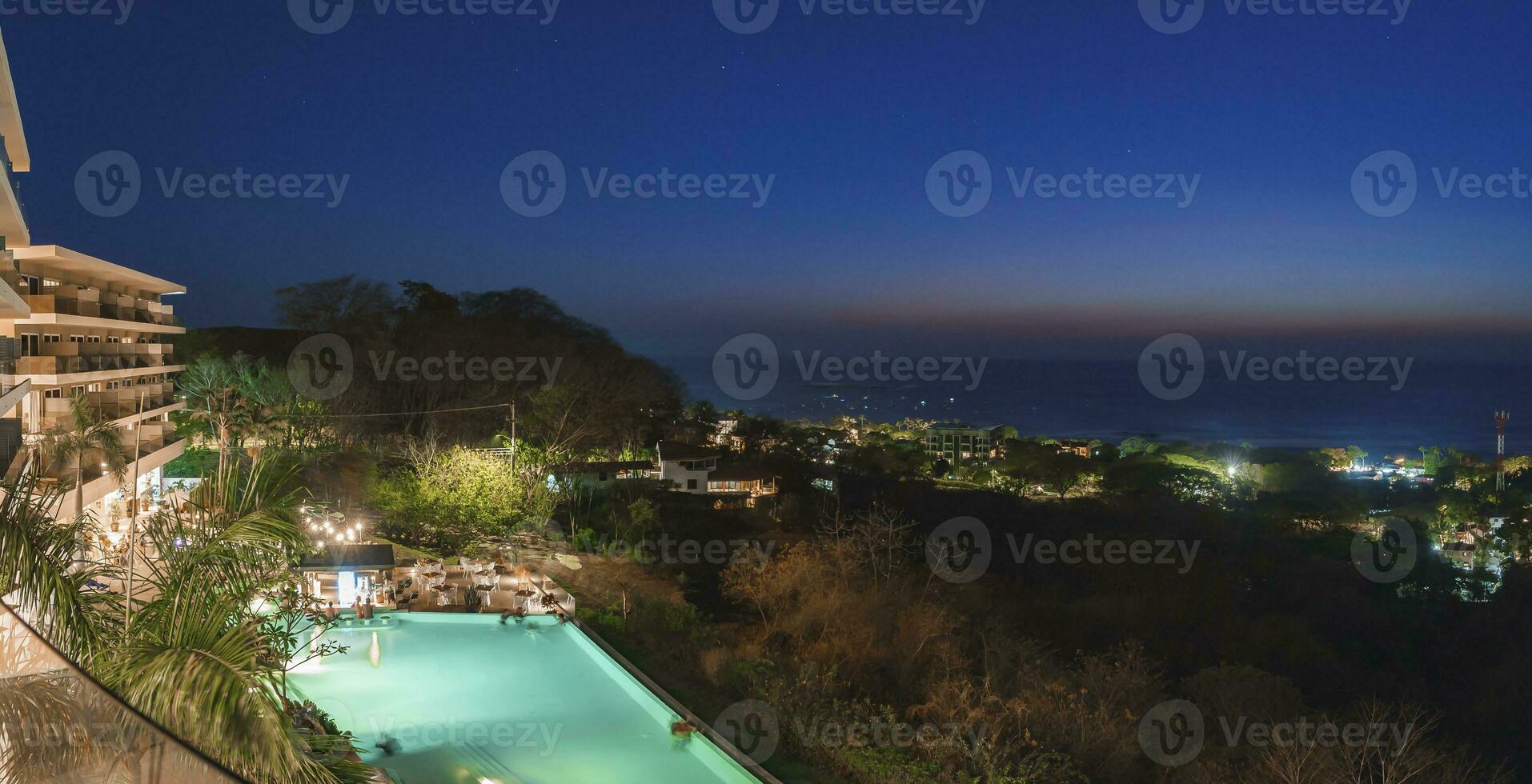 iluminado lujo recurso con turistas en nadando piscina a costa rica foto