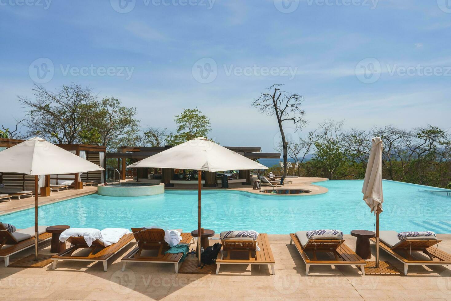 Lurury resort swimming pool with deck chairs and canopy photo