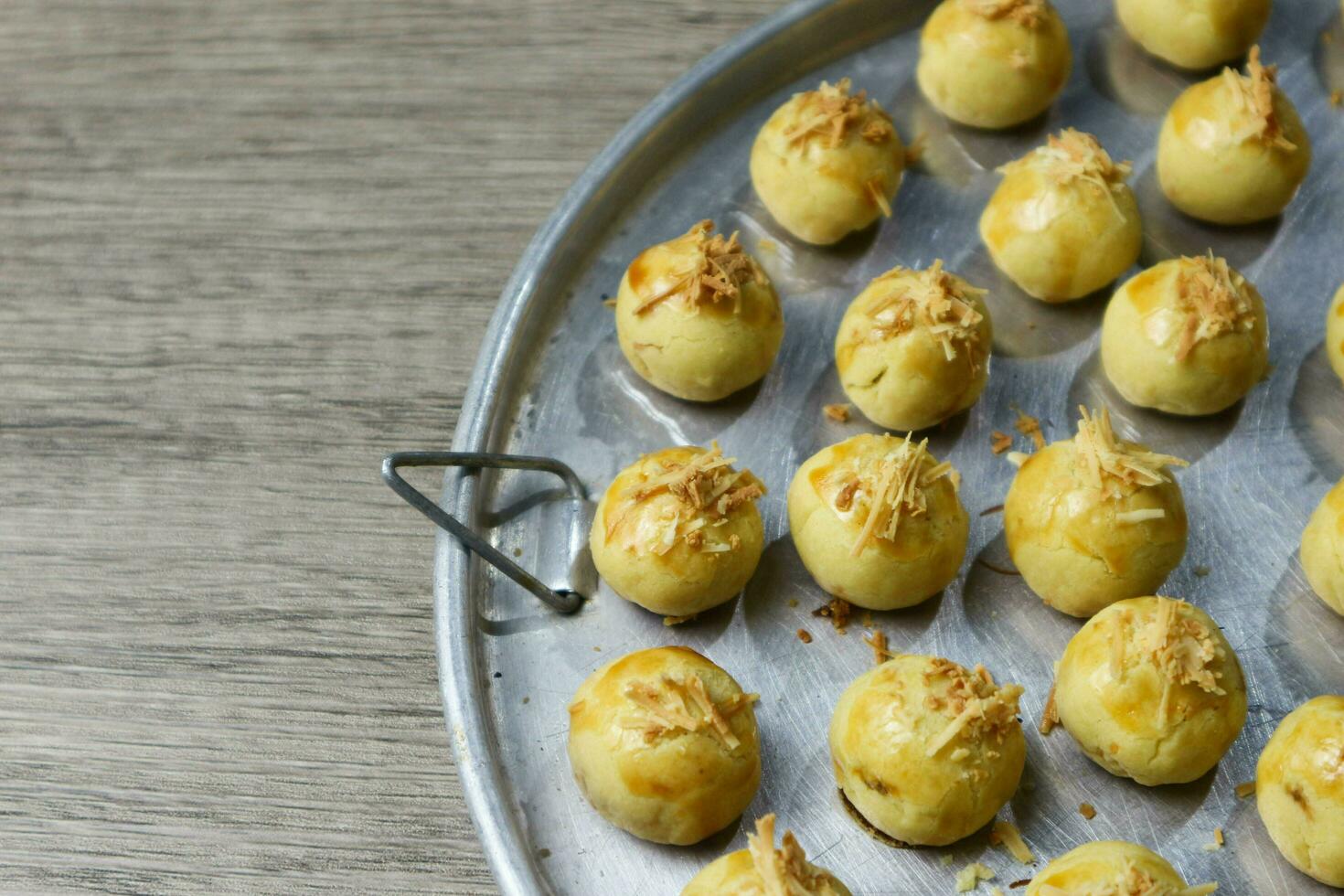 Nastar Keju. Homemade Pineapple Tart or Nastar Keju, cookies with pineapple jam filled and spread grated cheese on the aluminium pan, fresh from the oven. Served during Eid Al Fitri photo