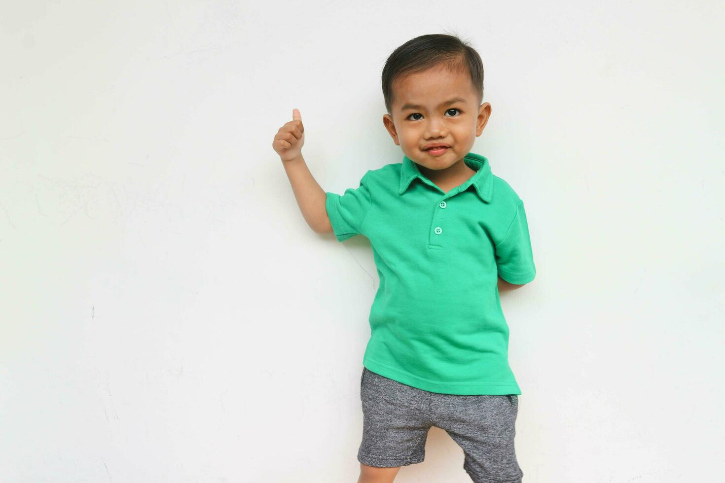 Portrait of a happy little Asian boy looking at camera while shouting on the white background photo